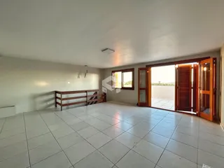 Vista ampla de uma sala com piso de cerâmica e acesso a uma área externa.