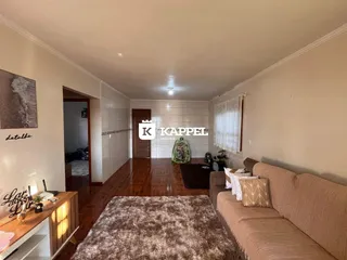 Sala de estar com sofá e piso de madeira aparente.