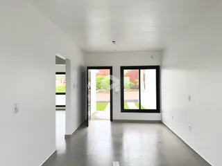 Hall de entrada com paredes brancas e piso claro.