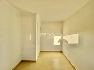 Interior de um corredor com paredes brancas e piso claro.