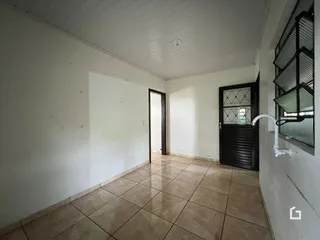 Vista de um corredor interno com piso de cerâmica e paredes brancas.