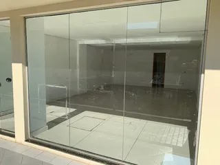 Vista interna de um ambiente com grandes painéis de vidro em uma propriedade em Lajeado.