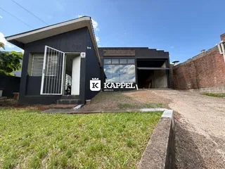 Fachada externa de uma residência escura com entrada e garagem.