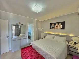 Quarto com cama e guarda-roupa branco em um imóvel.
