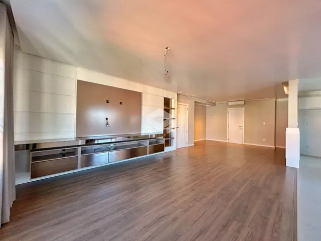 Sala de estar com piso de madeira e painel de destaque.