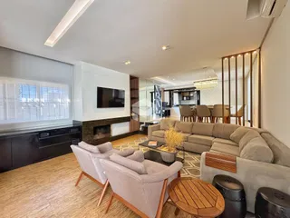 Sala de estar moderna com piso de madeira e sofá grande.