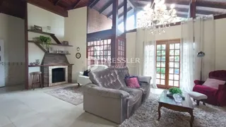 Sala de estar com lareira e grandes janelas em um imóvel no Brasil.