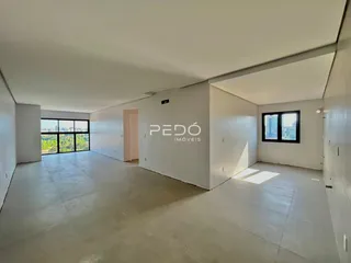 Interior de um espaço amplo com piso de concreto e paredes brancas.