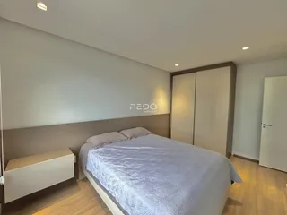 Quarto com cama e armários em um apartamento moderno.