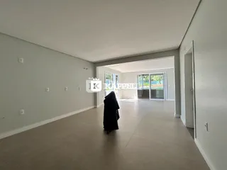 Vista de um corredor interno com paredes claras em uma propriedade.