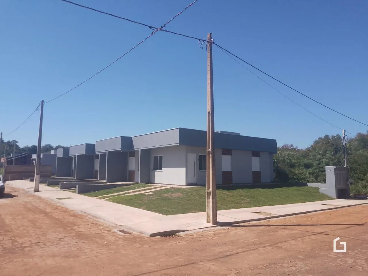 Fachada de casas modulares em Lajeado, Brasil, com gramado à frente.