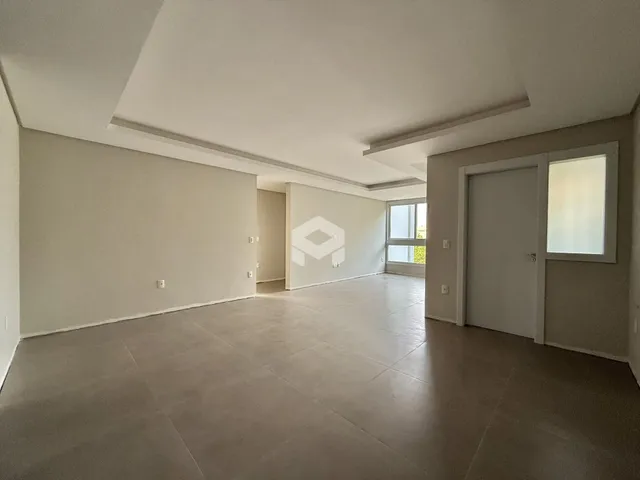 Um corredor amplo com paredes brancas e piso claro.