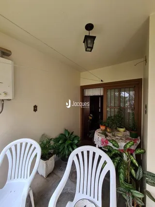 Canto interno de uma sala com paredes brancas e teto claro.