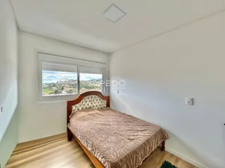 Quarto com vista para a paisagem através de uma grande janela.