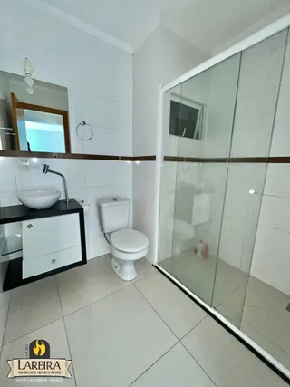 Foto de um banheiro interno com revestimento branco e piso claro.