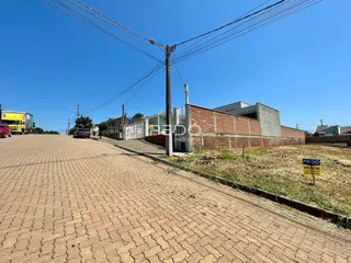 Fachada de uma propriedade em Lajeado, Brasil, com muro de tijolos e área pavimentada.