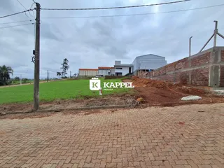 Vista externa mostrando um campo verde e estruturas ao fundo.