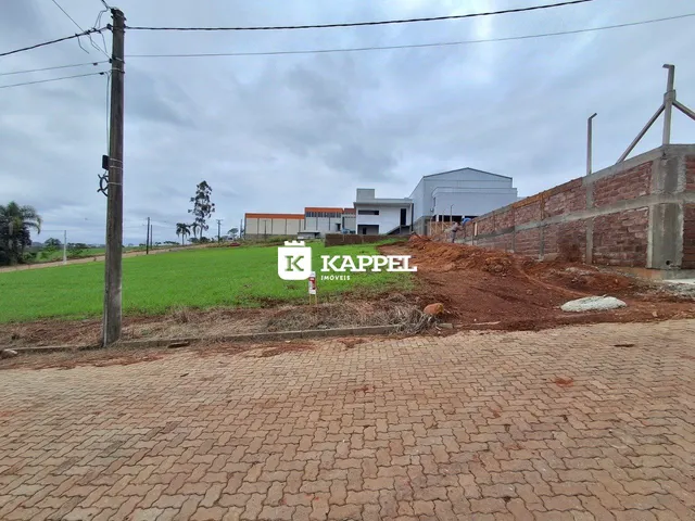 Vista externa mostrando um campo verde e estruturas ao fundo.