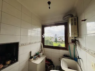 Interior de um banheiro com revestimento de azulejos brancos e janela.