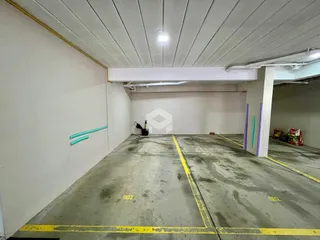 Espaço interno de concreto com paredes brancas e teto plano.