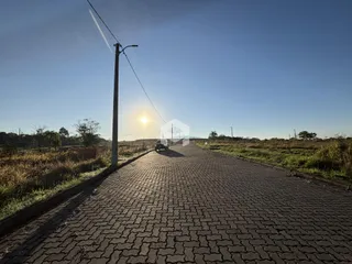 Uma estrada pavimentada se estende pela paisagem sob um céu claro.