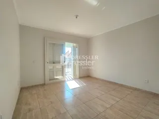Vista interna de um ambiente com piso de cerâmica claro.