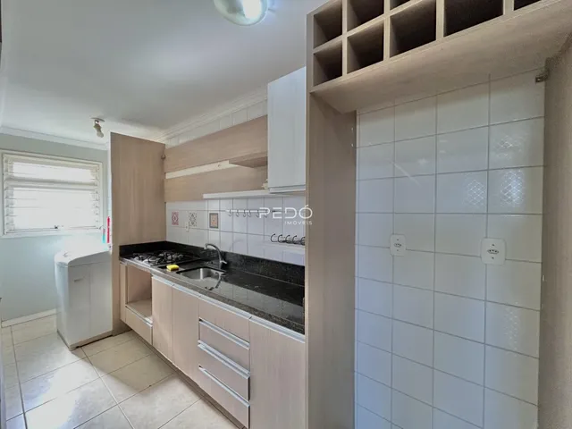 Cozinha com armários e bancada escura.