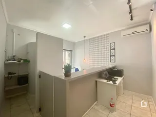 Vista interna de um ambiente com paredes brancas e piso de cerâmica.
