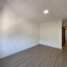 Vista interna de um cômodo com piso de madeira clara.