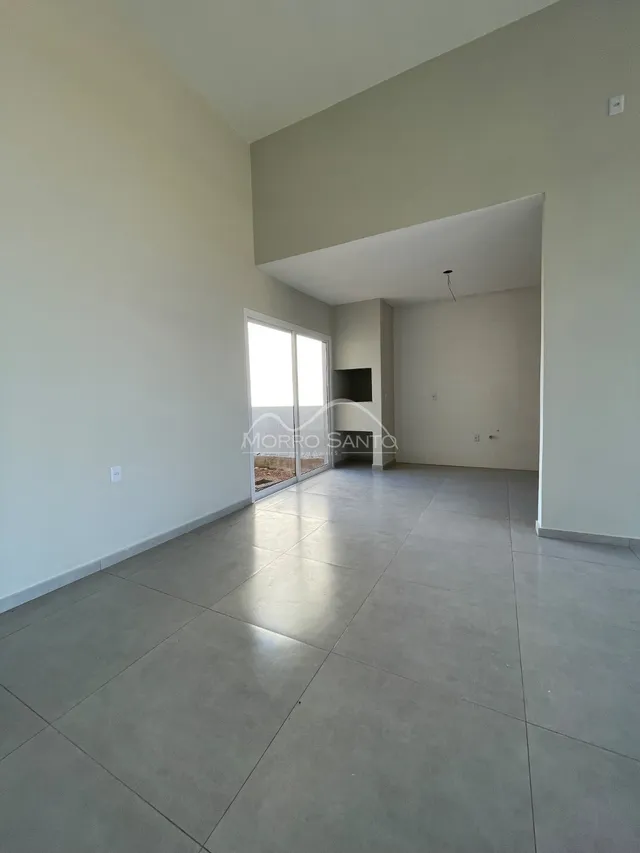 Ambiente interno amplo com piso de porcelanato e paredes brancas.