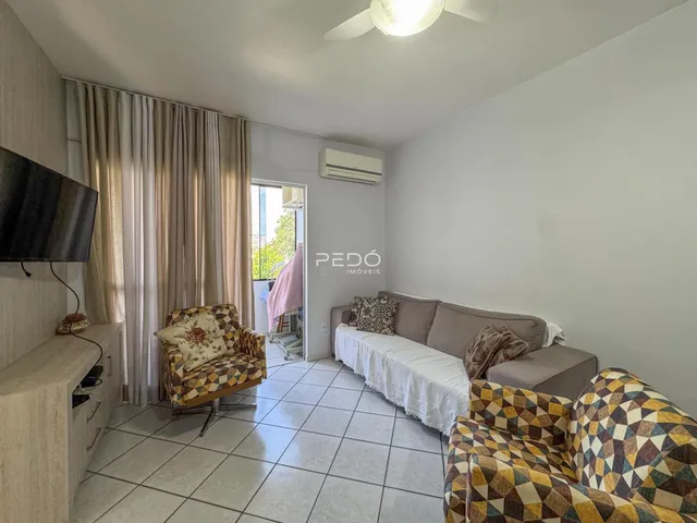 Sala de estar com sofá e poltronas decorativas em um apartamento.