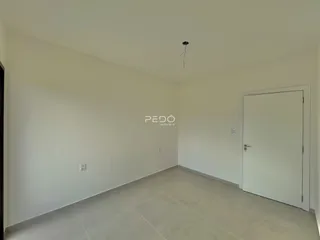 Vista interna de um cômodo com paredes brancas e piso claro.