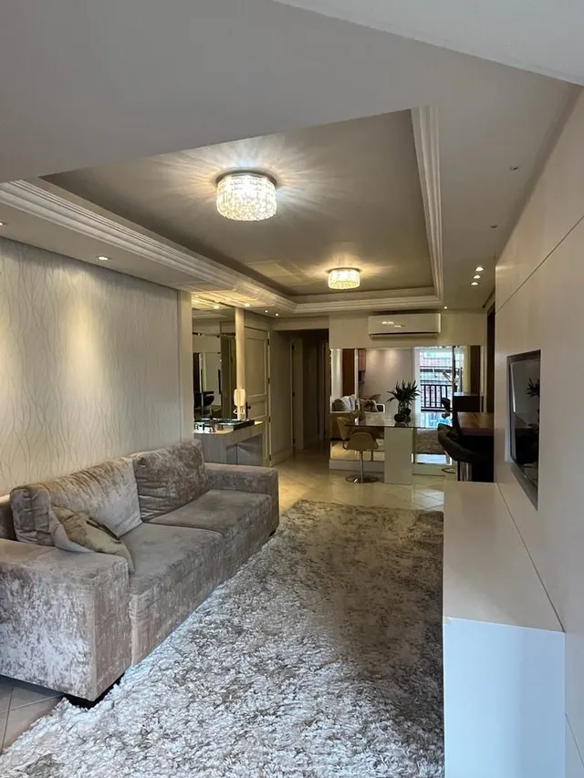 Foto de uma sala de estar com sofá e carpete em um ambiente interno.