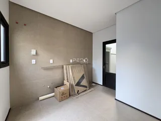 Interior de uma sala em construção com paredes bege e brancas.