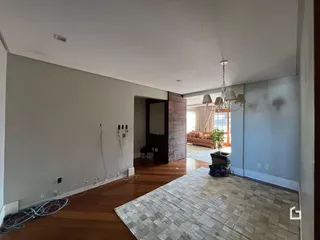 Vista de uma área comum com piso de madeira em uma residência.