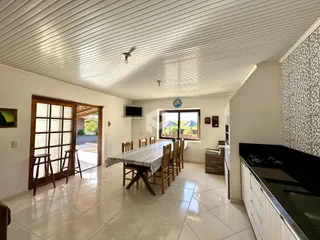 Ambiente interno de uma sala de jantar com piso de cerâmica e portas de madeira.