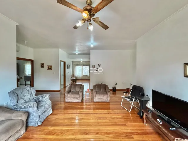 Sala de estar com piso de madeira e móveis.