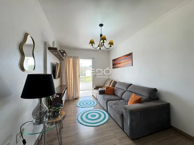 Sala de estar com sofá e piso de madeira clara.