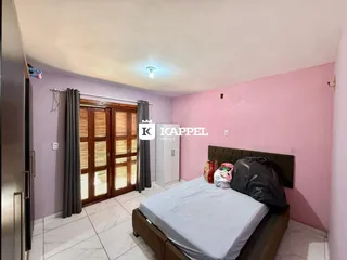Quarto com cama e portas de madeira em um imóvel.