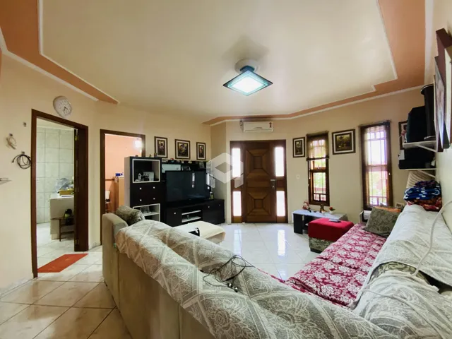 Sala de estar com sofá e televisão em ambiente residencial.