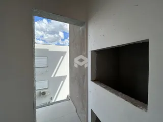 Detalhe da parede interna com nicho e abertura de porta em uma residência.