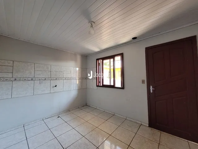 Hall de entrada com piso de cerâmica claro e parede branca.