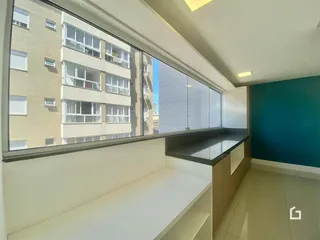 Sala de estar com grande janela oferecendo uma vista urbana.