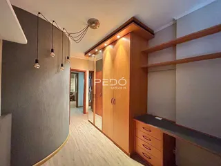Hall de entrada com piso de madeira e armário de madeira.