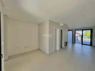 Interior de uma sala com paredes brancas e piso claro.