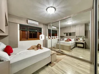 Quarto com cama de casal e persianas de madeira visíveis.
