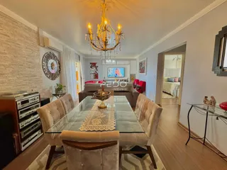 Sala de estar com sofá e mesa de vidro em um apartamento.