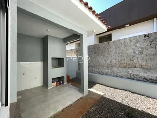 Vista da fachada de uma residência com área externa de concreto.