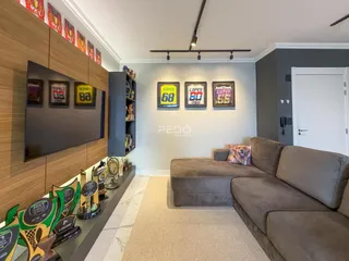 Sala de estar com sofá e televisão em um imóvel no Brasil.