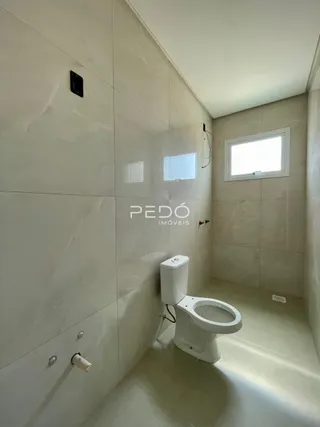 Foto de um banheiro interno com paredes brancas e piso claro.
